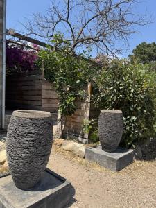 two stone vases sitting in front of a fence at Chambres d'Hôtes Terra Bella in Lecci
