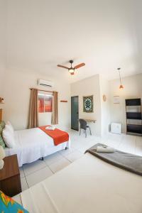 a hotel room with two beds and a desk at Sabiá Hospedagem - São Jorge in Sao Jorge