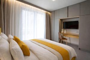 a bedroom with a bed and a desk and a television at Elysian Luxury Suite in Preveza +42 photos