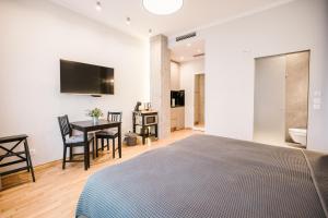 a bedroom with a bed and a desk and a television at Karlo Main Square Apartments in Zagreb