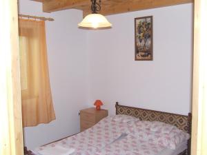 バラトンマーリアフュルドゥーにあるHoliday home in Balatonmariafürdo 19291のベッドルーム1室(ベッド1台付)が備わります。壁に絵が飾られています。