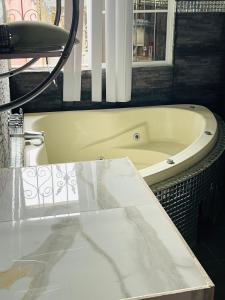 a white bath tub sitting in a bathroom at Amazon Jade Hotel Boutique in San Bartolomé Milpas Altas