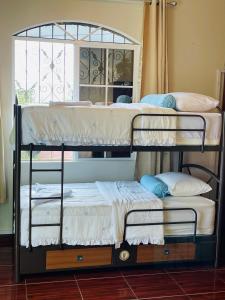 two bunk beds in a room with a window at Amazon Jade Hotel Boutique in San Bartolomé Milpas Altas