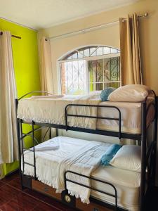 two bunk beds in a room with a window at Amazon Jade Hotel Boutique in San Bartolomé Milpas Altas +51 photos