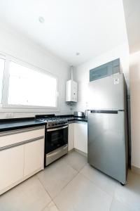 a kitchen with a stainless steel refrigerator and a window at Casa Iturraspe in Reconquista