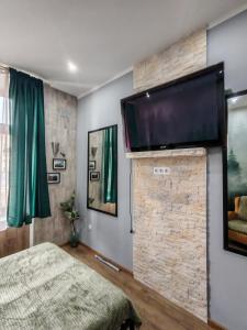 a bedroom with a flat screen tv on a brick wall at W pięknej KAMIENICY in Wałbrzych