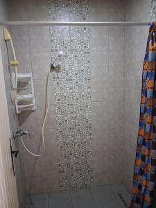 a bathroom with a shower with a shower curtain at Maison Amina Villa Novel in Triffa