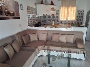 a living room with a couch and a table at Maison Amina Villa Novel in Triffa +5 photos