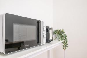 a television on a white shelf with a plant at Mandela Stadium Apartment in Florence +12 photos