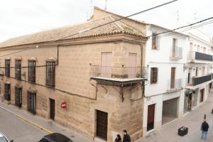 an old brick building with a balcony on a street at Balcones a San Pedro in Osuna