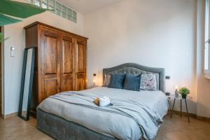 a bedroom with a large bed with a wooden cabinet at Mandela Stadium Apartment in Florence