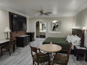 ein Hotelzimmer mit Bett, Tisch und Stühlen in der Unterkunft Hotel Siesta Real in Mexicali