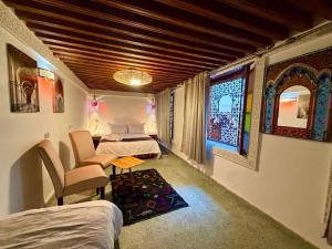a room with two beds and a table and chairs at Riad Fez Guests in Fez