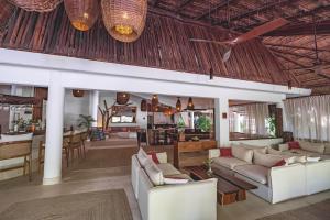 a living room with white couches and a dining room at The Beach Tulum Hotel in Tulum
