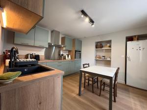 a kitchen with a table and a white refrigerator at Les Vendanges Maison Vigneronne in Reuilly