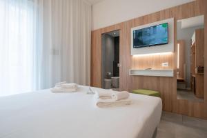 a hotel room with a bed and a tv on a wall at Hotel Iris Jesolo in Lido di Jesolo