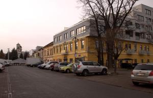 a row of cars parked in front of a yellow building at Apartment Centrum number 8 in Poprad