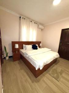 a bedroom with a bed with a cat laying on it at Oasis Residence in Arusha
