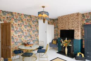 a living room with a table and a fireplace at Coastal Nest in Hollington