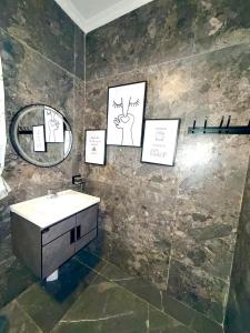 a bathroom with a sink and pictures on the wall at Oasis Residence in Arusha +6 photos