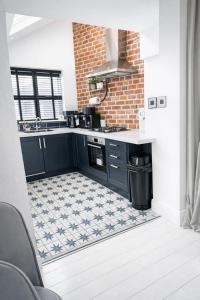 a kitchen with blue cabinets and a tile floor at Coastal Nest in Hollington