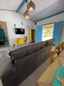a living room with a large couch and a table at Casinha Branca MSP - Casa na Quarta Praia in Morro de São Paulo
