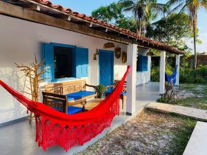a hammock on the porch of a house at Casinha Branca MSP - Casa na Quarta Praia in Morro de São Paulo