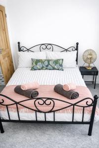 a bedroom with a bed with two towels on it at Coastal Nest in Hollington