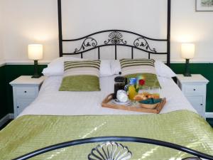 a bed with a tray of food on it at Juniper - 28060 in Wheddon Cross