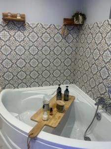 a bath tub with bottles sitting on top of it at Suite Une Bulle d Evidence avec baignoire spa in Saumur
