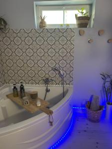 a bathroom with a bath tub with blue lights at Suite Une Bulle d Evidence avec baignoire spa in Saumur