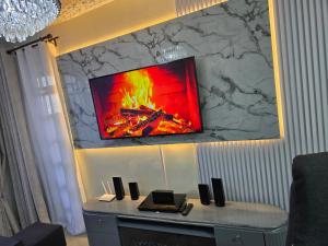 a tv hanging on a wall with a fire on it at Silvia Homes Nanyuki in Nanyuki