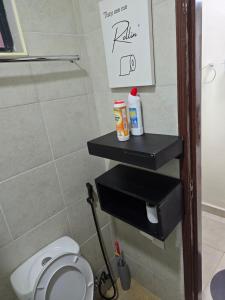 a bathroom with a toilet and a black shelf at Silvia Homes Nanyuki in Nanyuki +27 photos