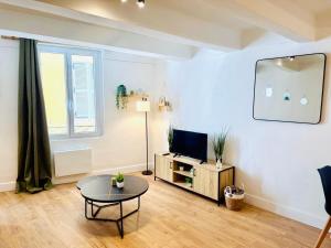 a living room with a table and a television at Studio neuf en hyper centre, moderne et calme in Toulon