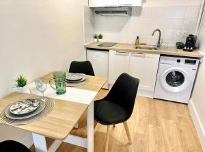 a kitchen with a table and a washing machine at Studio neuf en hyper centre, moderne et calme in Toulon