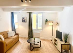 a living room with a couch and a table at Studio neuf en hyper centre, moderne et calme in Toulon