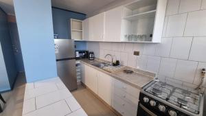 a white kitchen with a stove and a refrigerator at Dpto full amoblado en copiapo 4 in Copiapó +2 photos