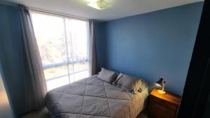 a blue bedroom with a bed and a window at Dpto full amoblado en copiapo 4 in Copiapó