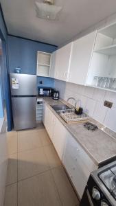 a kitchen with white cabinets and a stainless steel refrigerator at Dpto full amoblado en copiapo 4 in Copiapó