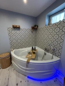 a large tub in a bathroom with blue led lights at Suite Une Bulle d Evidence avec baignoire spa in Saumur