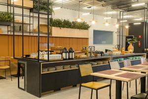 a restaurant with a counter with tables and chairs at Ibis Caruaru in Caruaru
