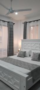 a bedroom with a large white bed with curtains at Nyali luxe 1 bedroom in Nyali +36 photos