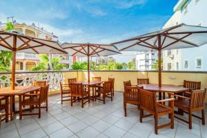 a patio with wooden tables and chairs and umbrellas at Nyali luxe 1 bedroom in Nyali