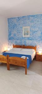 a bedroom with a wooden bed with blue wallpaper at Villa Petrusa in Stromboli