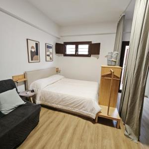 a bedroom with a bed and a couch at RC vacanze interno 57 in Rocca di Mezzo