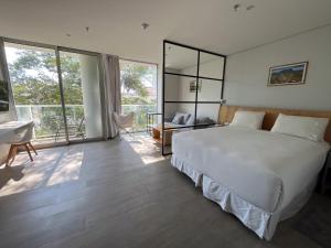 ein Schlafzimmer mit einem großen weißen Bett und einem Schreibtisch in der Unterkunft Solara Hotel Boutique in Asunción + 58 Fotos