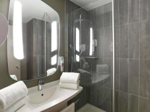 a bathroom with a sink and a mirror at Ibis Le Havre Sud Harfleur in Harfleur +39 photos