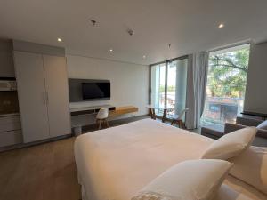 ein Schlafzimmer mit einem großen weißen Bett und einem Fernseher in der Unterkunft Solara Hotel Boutique in Asunción