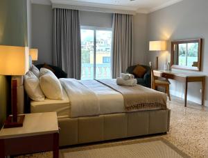 a bedroom with a bed and a desk and a window at Villa Sunny Side in Mellieħa