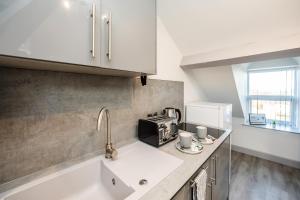 a kitchen with a sink and a microwave at Edgerton Stays in Huddersfield +14 photos